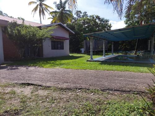 瓜拉弄宾ISLAMIC HOMESTAY @ KUALA ROMPIN , PAHANG .的一座带游泳池的房屋的后院