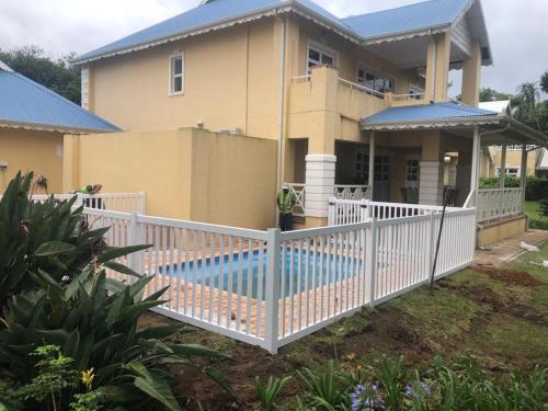 爱德华港Caribbean Estates: Barbados No. 12的房屋前的白色围栏,带游泳池