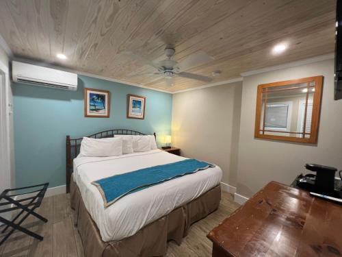 基韦斯特贝壳汽车旅馆及国际旅舍的一间卧室设有一张床和木制天花板