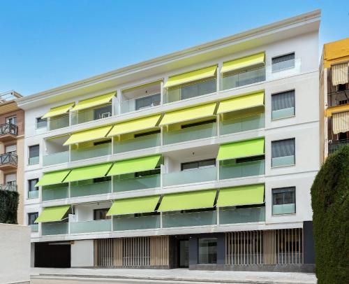 福恩吉罗拉Caleyro Boutique Apartments - "Parking incluido"的公寓大楼设有绿色和黄色的阳台