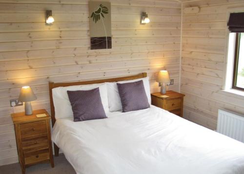 Newton KymeWighill Manor Lodges的一间卧室配有一张白色床、两个床头柜和两盏灯。