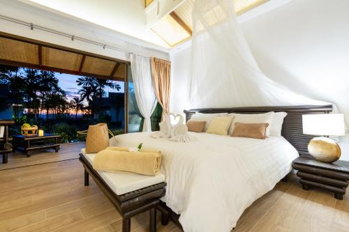 高兰Lanta Palace Beach Resort & Spa - Adult Only的卧室设有一张白色大床和一个庭院。