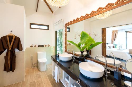 高兰Lanta Palace Beach Resort & Spa - Adult Only的一间带两个盥洗盆和大镜子的浴室