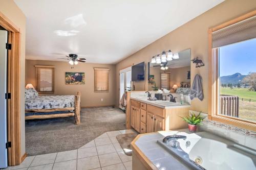 埃斯蒂斯帕克Family-Friendly Home with Hot Tub 1 Mi to Dtwn的一间带浴缸和水槽的浴室以及一间卧室