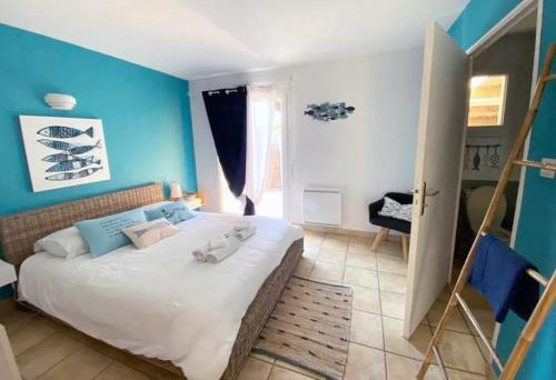 PlouarzelLa villa Ty Mor Braz的一间卧室配有一张带蓝色墙壁的大床