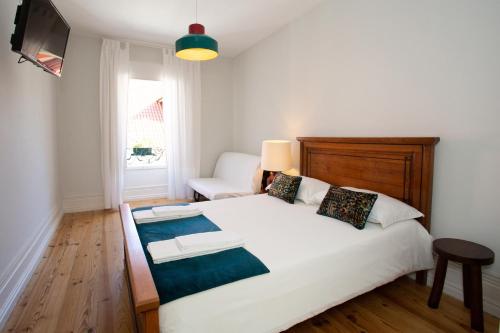 维塞乌VisHostel的卧室配有一张白色的大床和一张沙发。