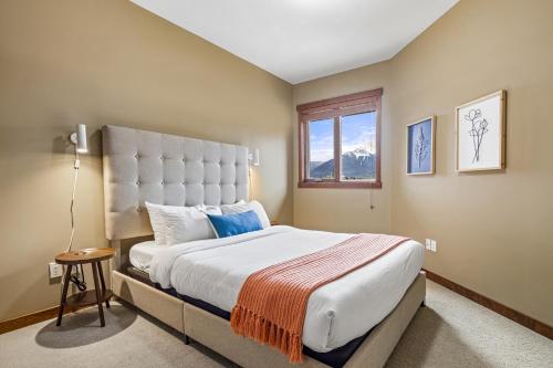 坎莫尔Alluring Mountain View Condo -Right In The Heart Of Downtown!! Hosted by Fenwick Vacation Rentals的一间卧室设有一张大床和一个窗户。