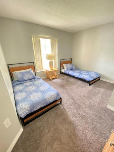 奥兰多DWS度假屋的一间卧室设有两张床和窗户。