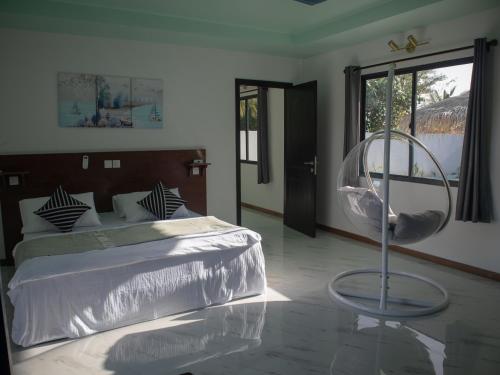 甘岛Clouds Beach Retreat Laamu Gan的一间卧室配有一张床、一把椅子和镜子
