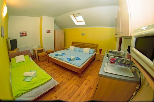 VažecVila Rhea的小房间设有两张床和电视