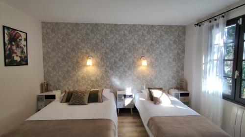 龙斯莱班Maison "Les Agathines"的酒店客房设有两张床和窗户。