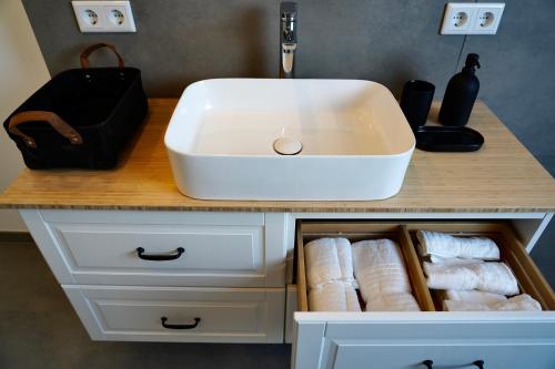 伍珀塔尔Luxuriöse Maisonette Wohnung im Szenenviertel的浴室梳妆台配有白色水槽和毛巾