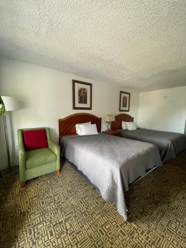 基西米国宾旅馆 的酒店客房,设有两张床和一把绿色椅子