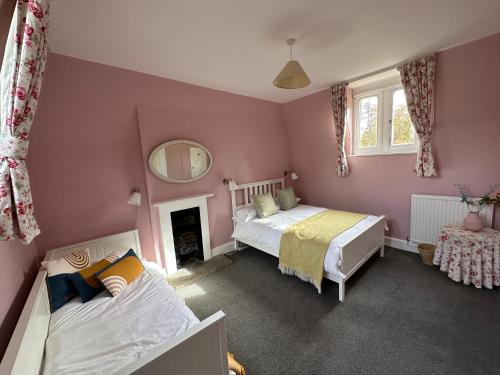 布罗肯赫斯特Historic 2 bed gatehouse in private parkland的一间卧室配有两张床和镜子