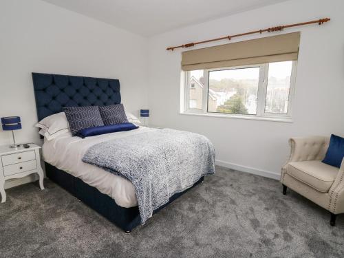 阿伯里斯特威斯Ty Melyn的卧室配有床、椅子和窗户。