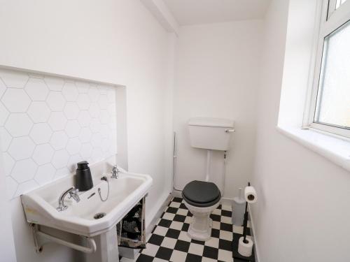 阿伯里斯特威斯Ty Melyn的浴室铺有黑白格子地板。