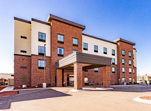 苏必利尔Cobblestone Hotel & Suites - Superior Duluth的停车场内有遮阳篷的大型砖砌建筑