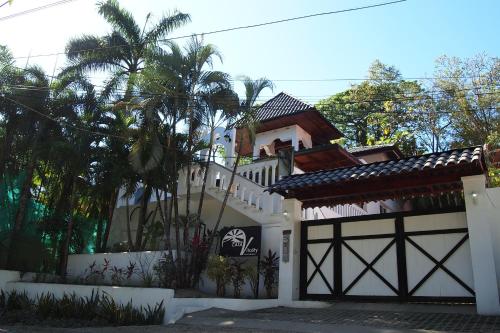 诺萨拉Casa Vitality Nosara的一座白色的房子,有门和棕榈树