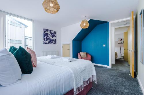 曼彻斯特Townhouse 5mins to City Centre and Etihad - Free Secure Parking的一间卧室设有一张大床和蓝色的墙壁
