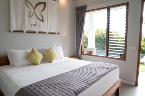 坎古Bali Harmony Retreat的一间卧室设有一张大床和一个窗户。