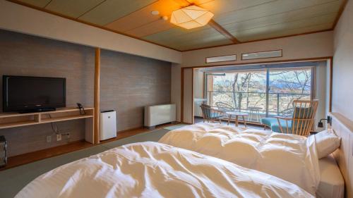气仙沼市Kyukamura Kesennuma-Ohshima的一间卧室配有一张床和一台平面电视
