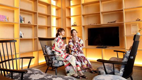 鹤冈市Kyukamura Shonai-Haguro的两个女人坐在一个房间里摇椅上