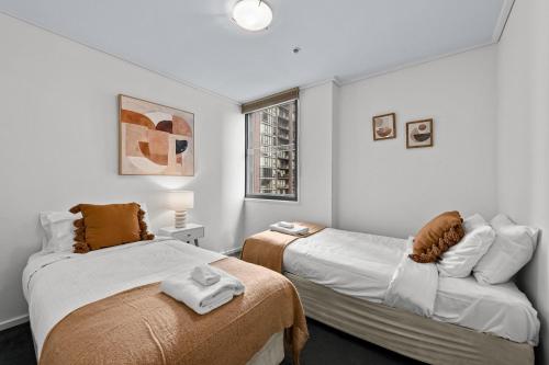 墨尔本独家住宿 - 萨米特公寓的一间卧室设有两张床和窗户。