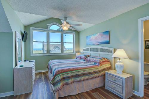 托普赛尔海滩Park Topsail Beach的一间卧室配有一张床和吊扇