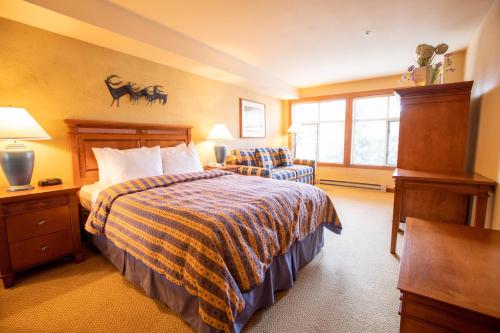 索利图德3309B - Queen Standard Powderhorn Lodge condo的配有一张床和一把椅子的酒店客房