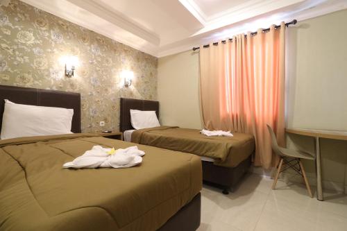 雅加达Flamenco Urban Living的酒店客房,配有两张带毛巾的床