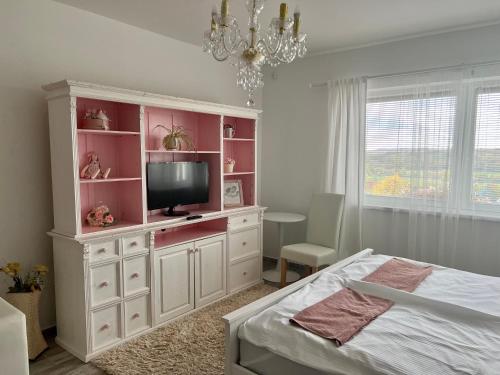 锡尔沃斯瓦里德Gold Horse Vendégház的一间卧室配有一个大型白色橱柜,内配电视