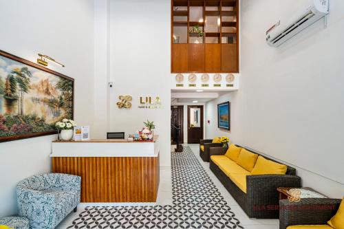 胡志明市LILA Hotel & Apartments的客厅配有黄色的沙发和椅子