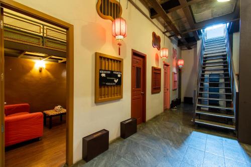 吉隆坡尚街旅游中心酒店的大楼内带红色沙发的走廊和楼梯