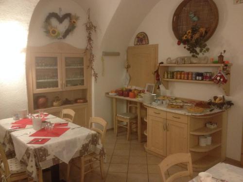特伦托Agriturismo La Decima的厨房配有桌子、柜台和桌椅