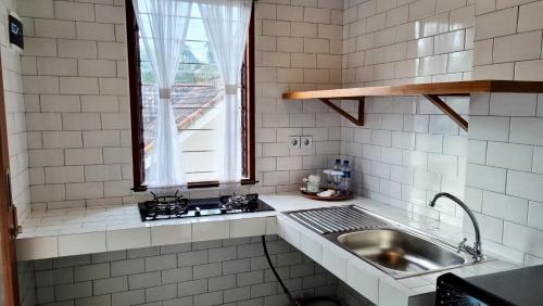 登巴萨奥马萨假日公园的厨房设有水槽和窗户。