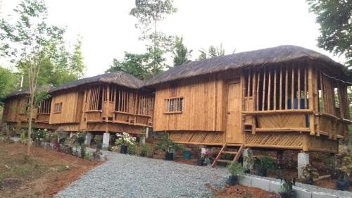 BolinaoVirgin River Resort and Recreation Spot的两座大木小屋,后面有树木