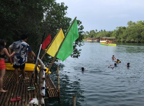 BolinaoVirgin River Resort and Recreation Spot的一群人,在水中,有旗帜