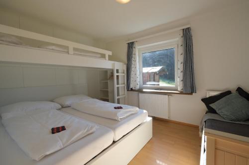 蓬高地区埃本GO FOR MOUNTAINS Appartements的卧室配有白色的床和窗户。