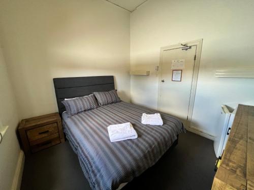 布罗肯希尔Black Lion Inn Hotel的一间卧室配有一张床,上面有两条毛巾