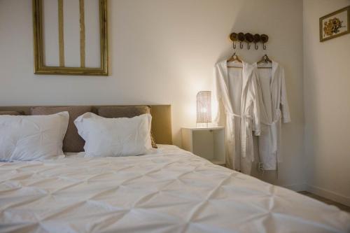 OostmalleVakantiehuis sINNE的一间卧室配有一张床,墙上挂着一个长袍