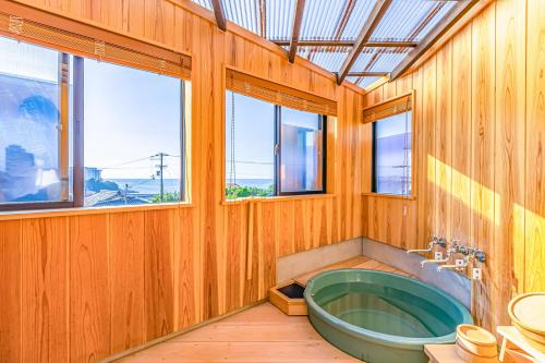 白滨LONG VACATION的一间带绿色浴缸和窗户的浴室