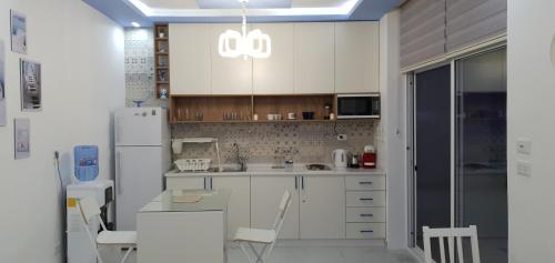 安曼Santorini Breeze Chalet的厨房配有白色橱柜和白色冰箱。