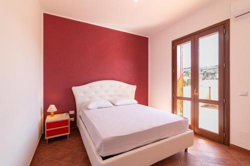 库斯托纳奇Appartamento Custonaci Uno的卧室配有白色的床和红色的墙壁