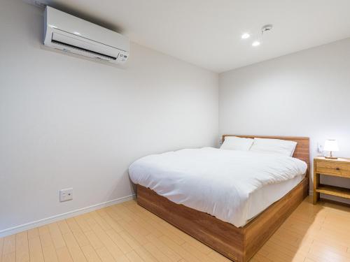 ItoshimaRakuten STAY HOUSE x WILL STYLE Itoshima 104的白色卧室配有床和空调