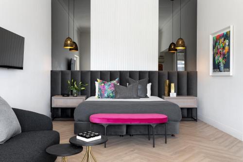 开普敦克拉伦登 - 佛伦斯奈尔酒店的一间卧室配有一张带粉红色座椅的大床