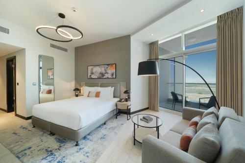 迪拜DAMAC Hills 2 Hotel, an Edge by Rotana Hotel的酒店客房,配有床和沙发