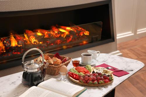 伊斯坦布尔Gatto Suites&Residence的餐桌,带食物盘和壁炉