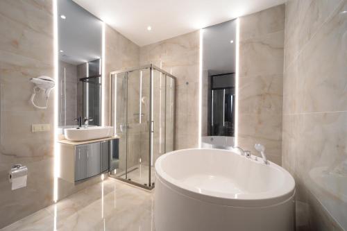 伊斯坦布尔Gatto Suites&Residence的白色的浴室设有浴缸和水槽。