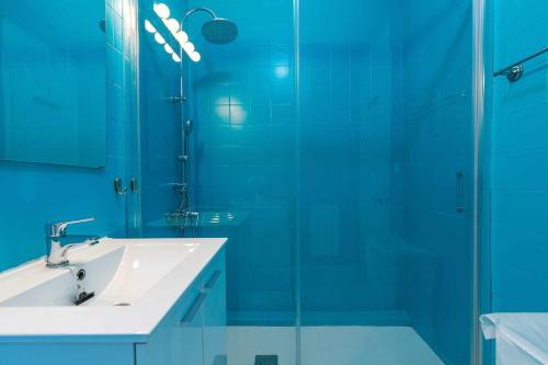 马德里Confortable piso 3 habitaciones en Retiro Atocha的一间带水槽和玻璃淋浴的浴室