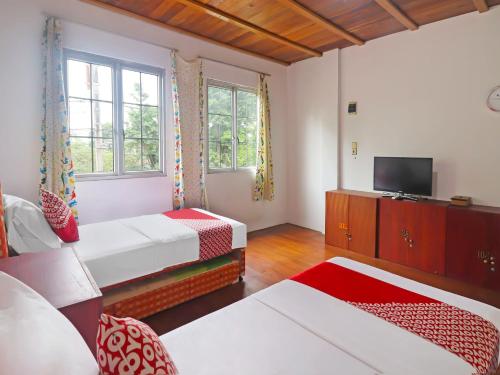 占碑市OYO 91807 Kemalasari Guesthouse的酒店客房设有两张床和电视。